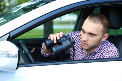 Man in car with binoculars